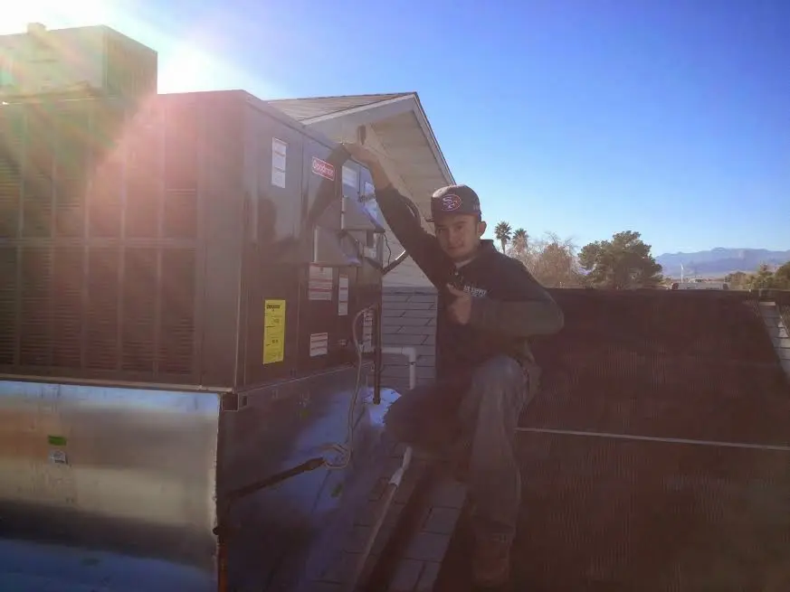 HVAC technician performing Heat Pump Repair on a rooftop unit in Stratmoor